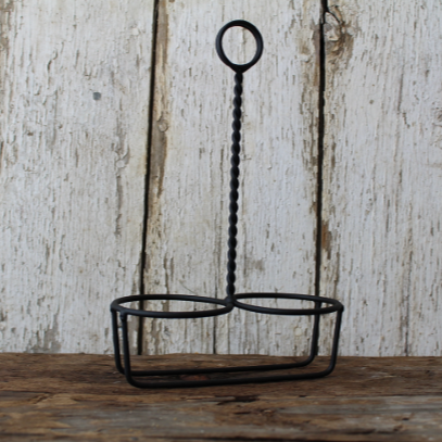 A black metal milk bottle holder with a single hook on top, designed to hold candles.