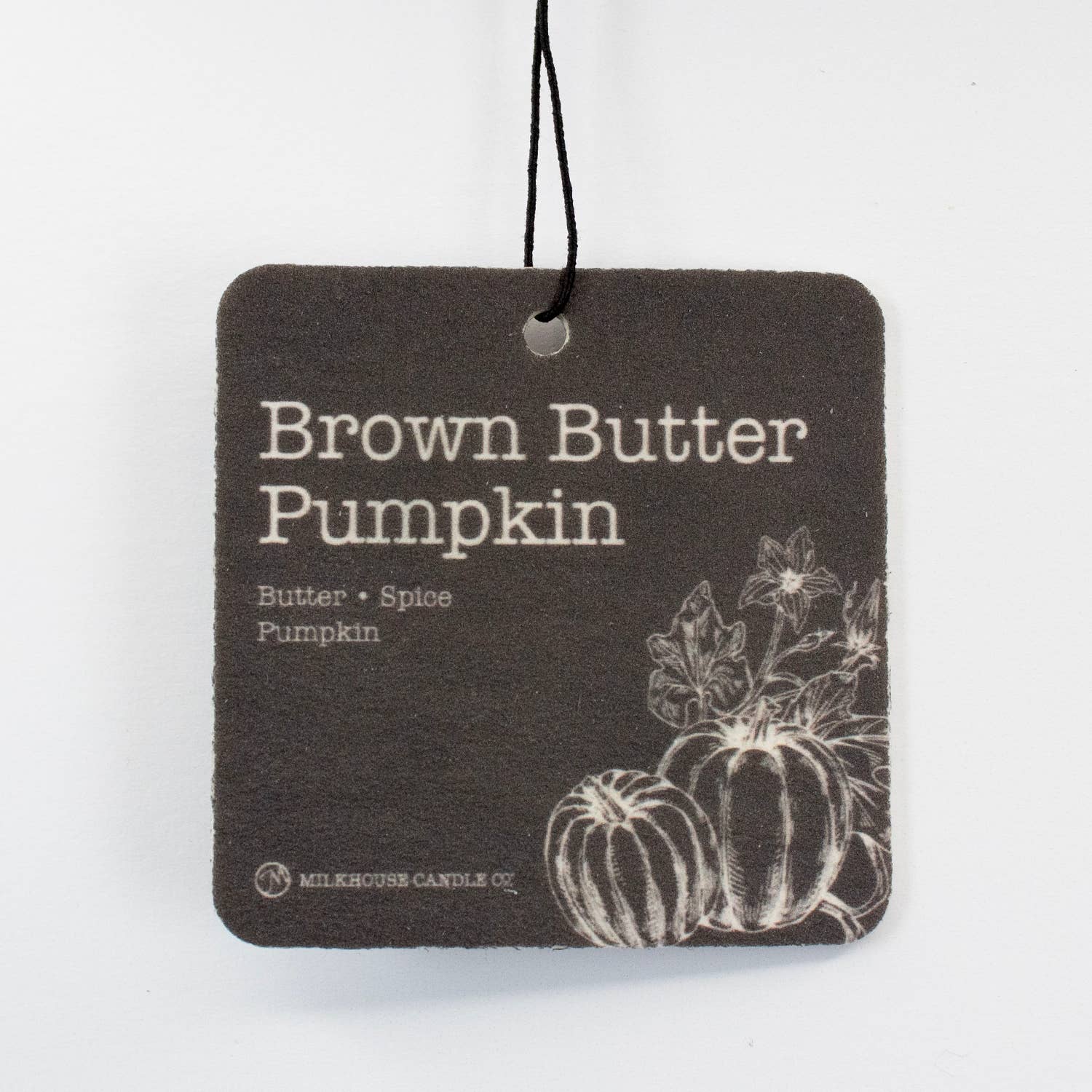 A square-shaped brown card with the text 'Brown Butter Pumpkin' and an illustration of pumpkins, indicating a fragrance from Milkhouse Candle Co.