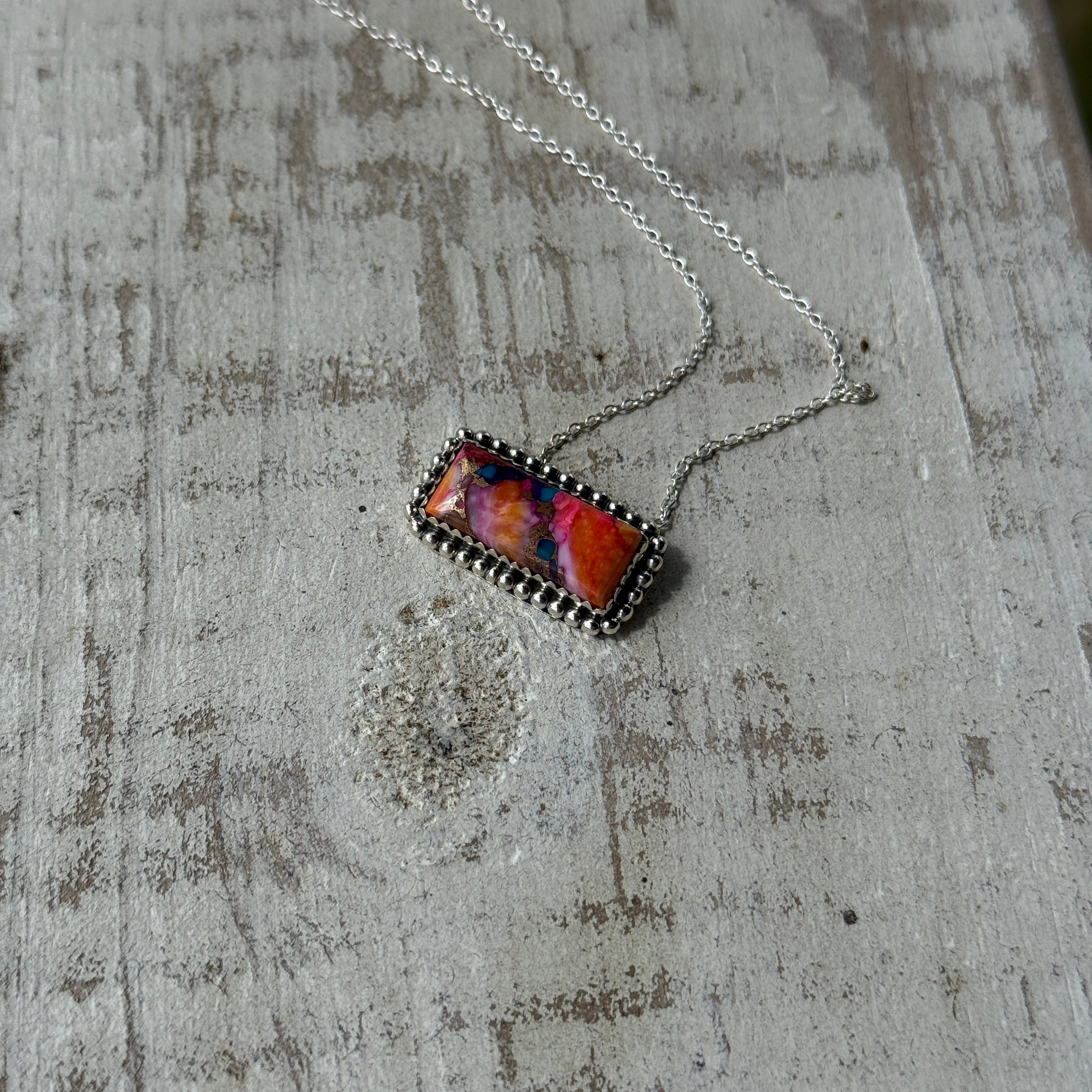 Necklace with a colorful pendant on a textured surface