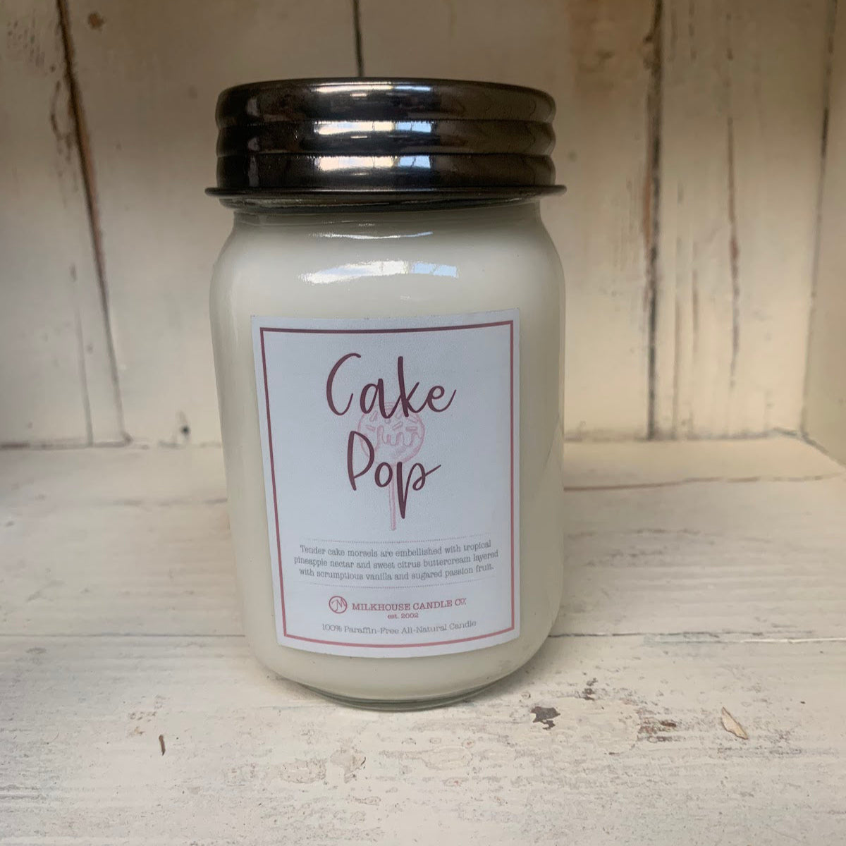A white 13 oz mason jar candle with a label that reads 'CAKE POP'.