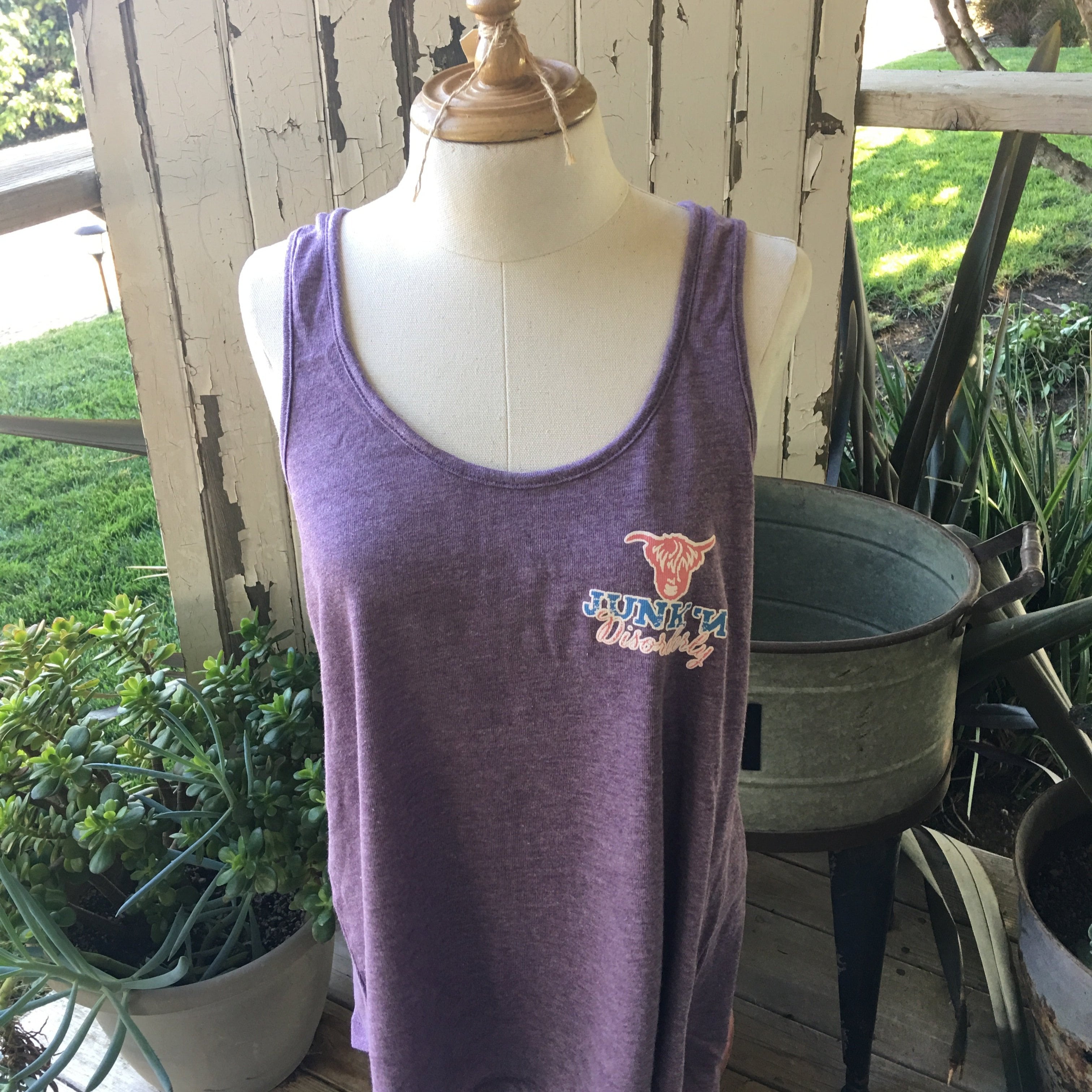 A purple Bella Canva tank top displayed on a mannequin, featuring a scoop neckline and a graphic on the front.