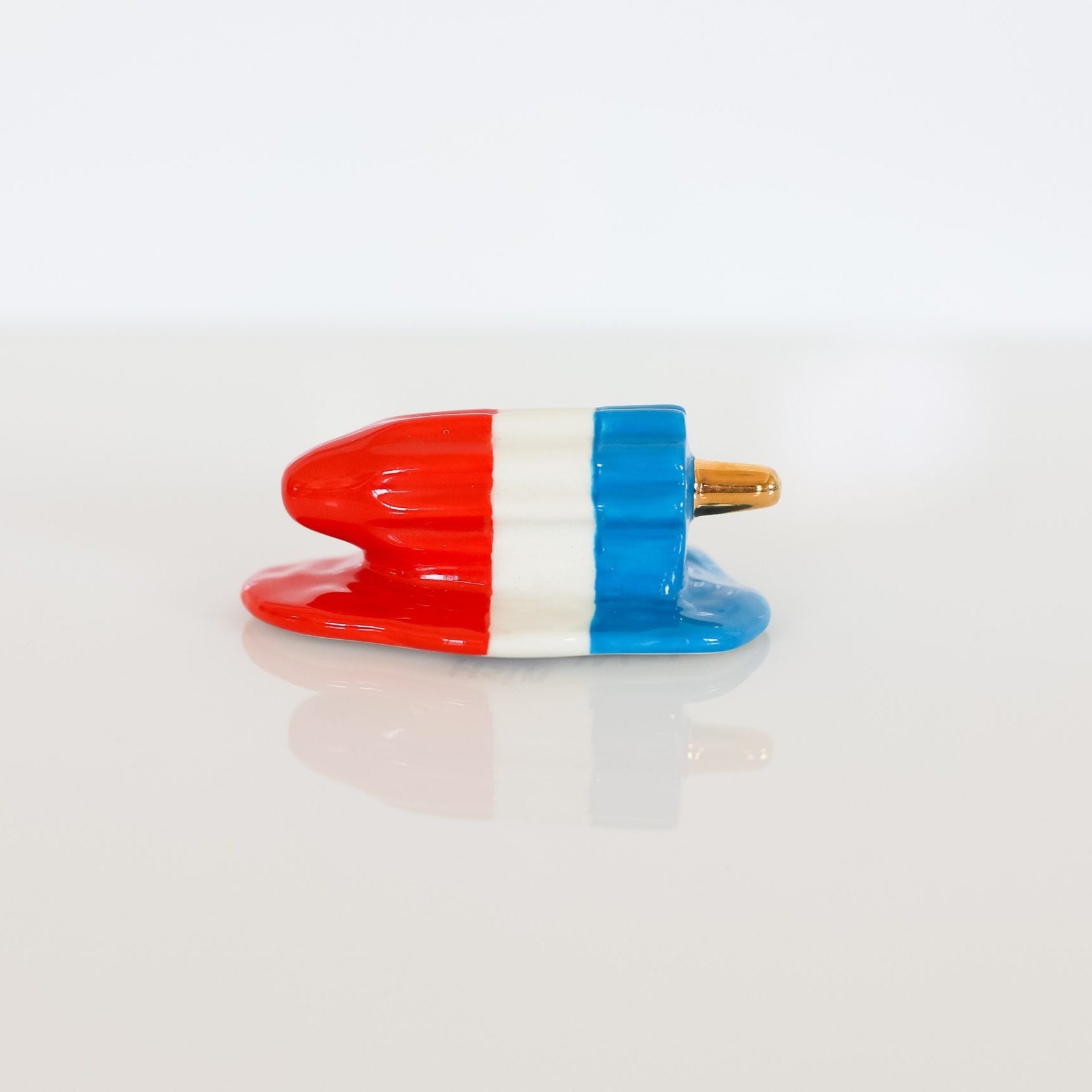 A multicolored cooling rack with red, blue, and white colors designed for kitchen use.